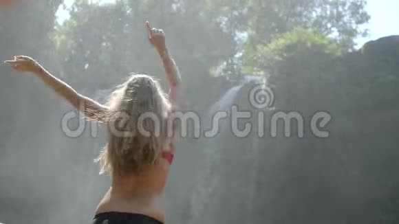 年轻女子横渡瀑布视频的预览图