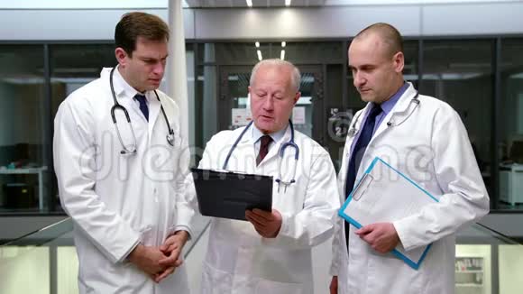 一队医生在剪贴板上讨论视频的预览图