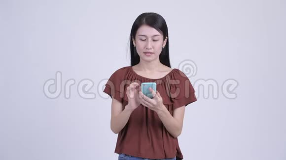 快乐美丽的亚洲女人用电话得到好消息视频的预览图