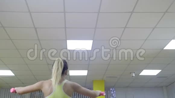 古典健美肌肉发达的金发健身女人在健身房锻炼健身健康生活方式的概念视频的预览图