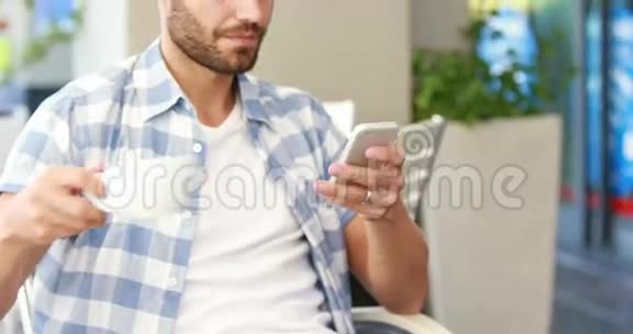 帅哥用智能手机喝咖啡视频的预览图