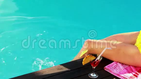 女人在游泳池里用鸡尾酒晃着腿视频的预览图