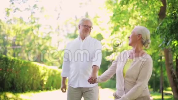 快乐的老两口在夏季城市公园散步视频的预览图