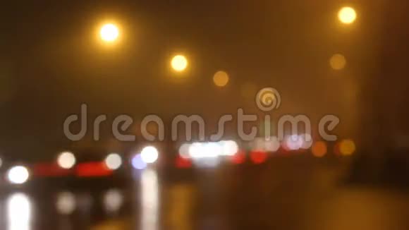 雾中模糊的城市灯光和道路上的汽车视频的预览图