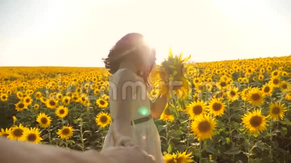 爸爸和女儿沿着田野走着夕阳下向日葵牵着手第一人称的景色慢速视频视频的预览图