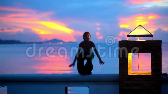 日落时分做瑜伽运动的年轻女子视频的预览图