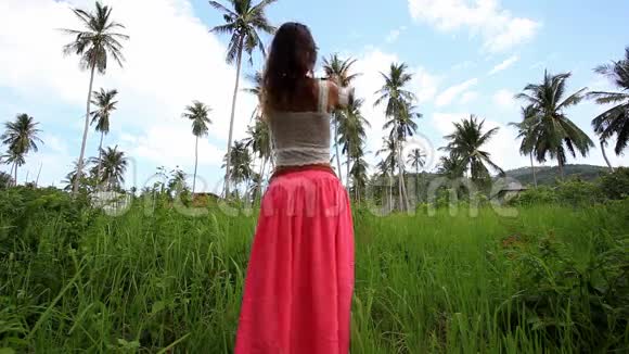 女人在丛林里拍棕榈树的照片视频的预览图