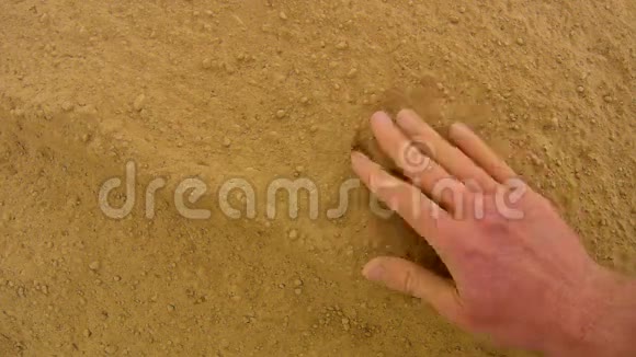 粉红色的皮肤手在极度干燥的粘土中寻找东西温柔的风带走了手掌的灰尘手指间的灰尘视频的预览图