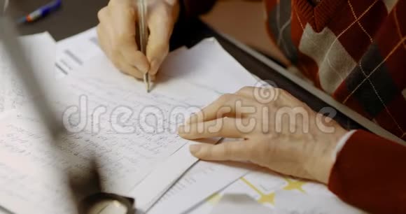 高级商人在办公室桌上写字视频的预览图