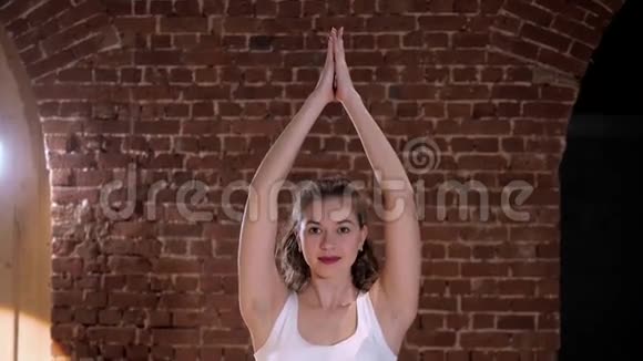 在砖背景的阁楼工作室做瑜伽的漂亮年轻女人的肖像视频的预览图