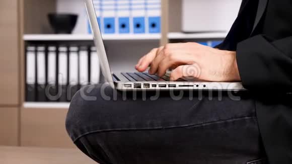 穿着正式西装的商人在笔记本电脑键盘上打字视频的预览图