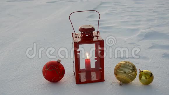 在冬天的雪地上放圣诞球和蜡烛视频的预览图