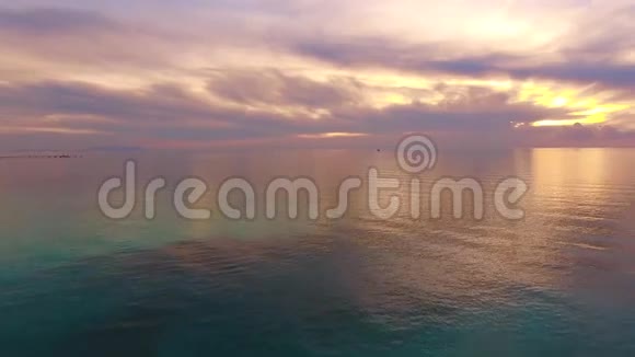空中拍摄令人难以置信的美丽平静的大海在夕阳的光芒与许多云视频的预览图