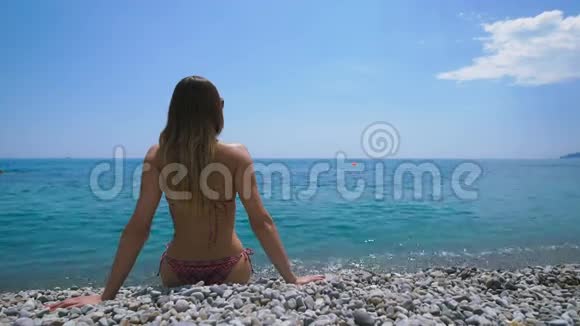 年轻迷人的女人在海滩上放松视频的预览图