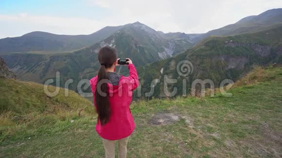一位年轻的女士在山上拍照视频的预览图