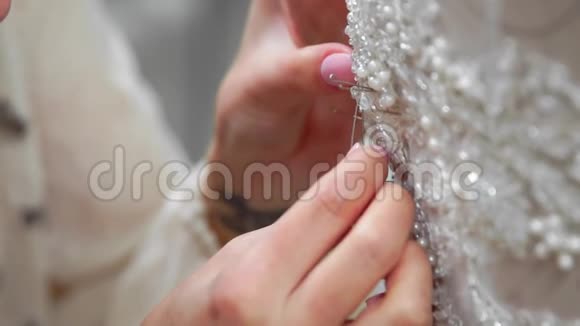 贴身时装设计师为新娘在他的工作室针花边婚纱女裁缝创造了独一无二的视频的预览图