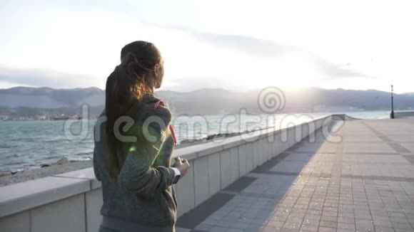 穿着帽衫在海滨城市慢跑的年轻女子视频的预览图