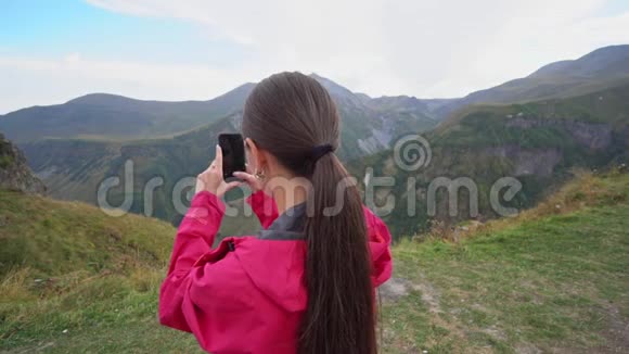 一位年轻的女士在山上拍照视频的预览图