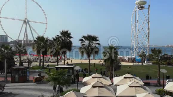 在JBRJumeirah海滩住宅和AinDubai摩天轮中漫步的人的时间推移视图视频的预览图