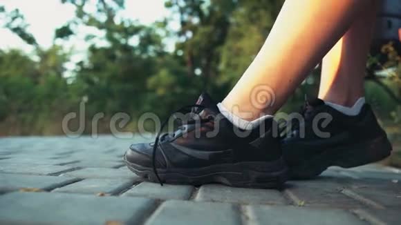 女赛跑运动员把鞋带系在运动员的慢动作上视频的预览图