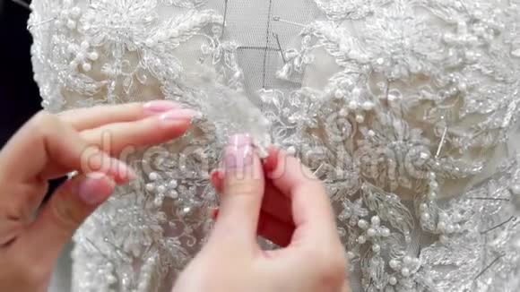 贴身时装设计师为新娘在他的工作室针花边婚纱女裁缝创造了独一无二的视频的预览图