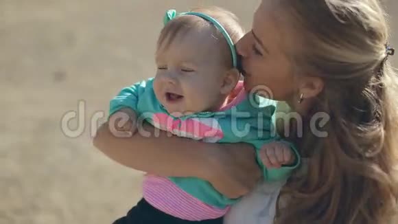 美丽的母亲抱着婴儿亲吻她视频的预览图