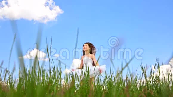 快乐女孩在绿色草地上跳跃视频的预览图