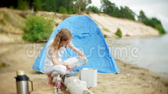 女人在露营时用帐篷做食物视频的预览图