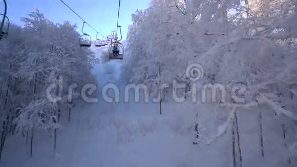滑雪缆车上的雪林和滑雪者视频的预览图