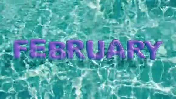 单词2月形状的充气游泳圈漂浮在清爽的蓝色游泳池里视频的预览图