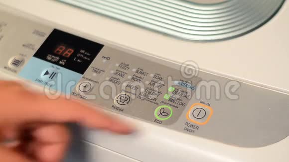 男性手按电源按钮启动洗衣机视频的预览图