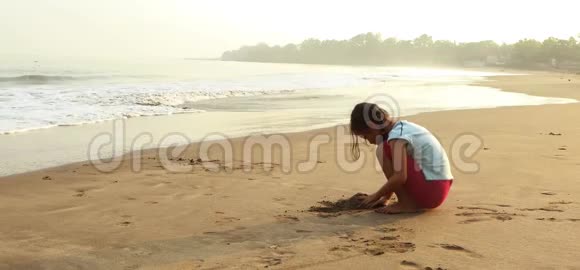 小女孩在海边玩沙子视频的预览图