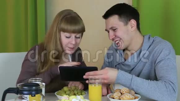 年轻快乐的一对情侣在看平板电脑视频的预览图