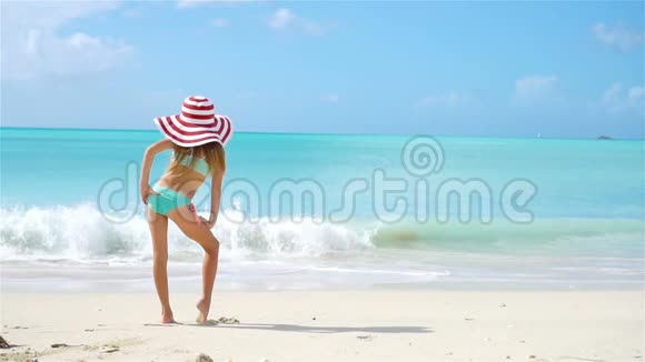 可爱的小女孩戴着大帽子在海滩上快乐的孩子享受暑假视频的预览图
