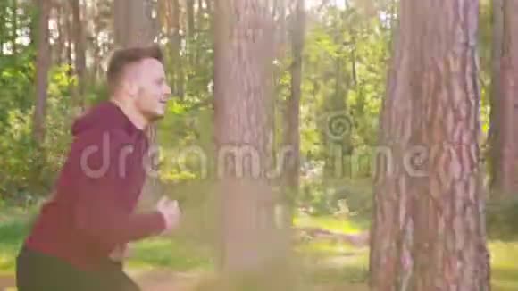 在森林里奔跑的年轻人视频的预览图