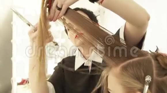 美发沙龙理发师梳理女性头发用专业剪刀剪关闭剪发工视频的预览图