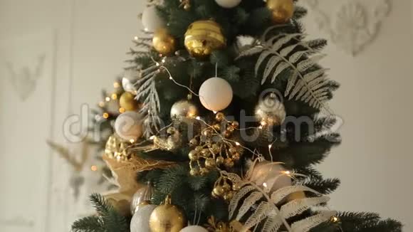 时尚的白色圣诞内部装饰杉树用满是金色装饰的圣诞树来舒适的家视频的预览图