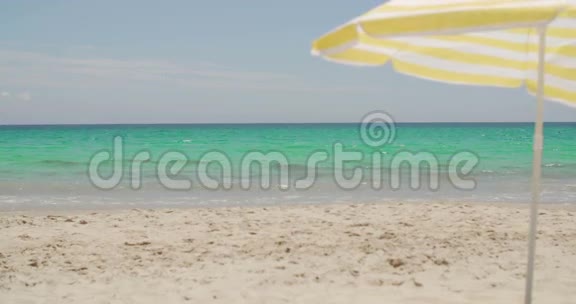 阳光明媚的热带海滩上的沙滩伞视频的预览图