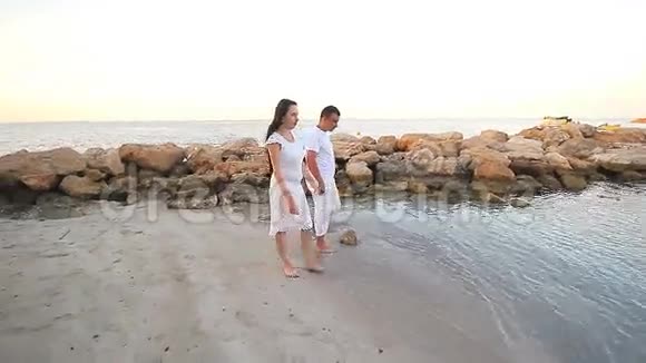在海滩上散步的夫妇年轻快乐的混血儿视频的预览图