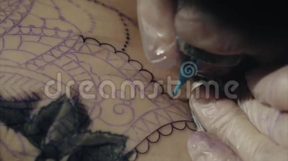 手套上纹身艺术家手的特写纹身图案在身体宏观上视频的预览图