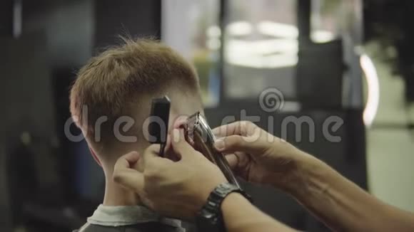 男式理发用电动剃须刀把头发修剪整齐的发型收起来理发师为理发店的顾客理发视频的预览图