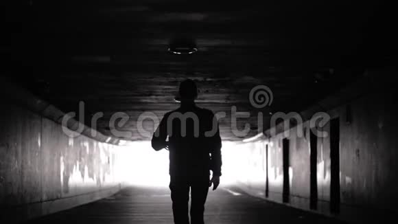 黑暗男人的轮廓在隧道里行走的人概念抑郁视频的预览图