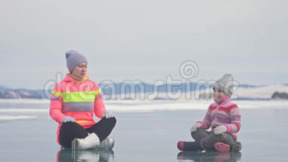 家人在冬天训练练习瑜伽女人在大自然中做伸展和冥想母亲和女儿视频的预览图