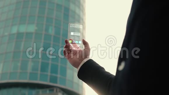 在现代商业建筑的背景下一个人手里拿着一部未来主义的科技全息手机视频的预览图