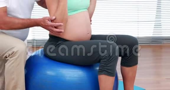孕妇在运动球上举起哑铃视频的预览图