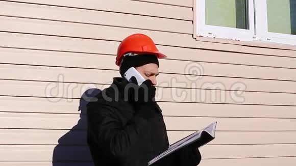 冬天工地上的工人在智能手机上讲话视频的预览图