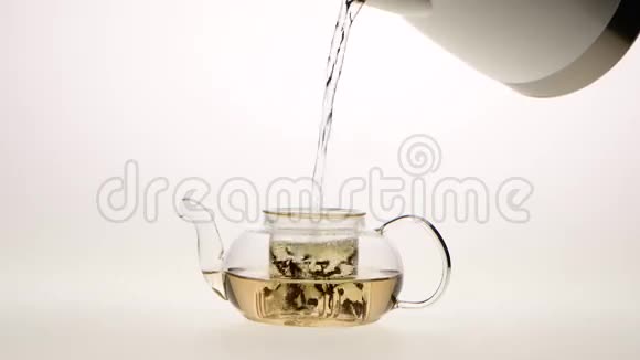 绿茶的叶子是用茶壶冲泡的白色的背景视频的预览图