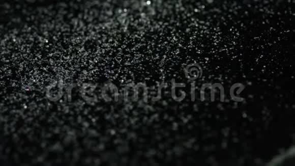 近距离观看盐或糖白色颗粒躺在黑色背景上库存录像白色和黑色的概念视频的预览图