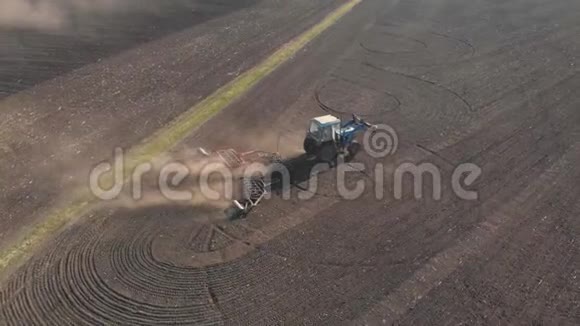 日落时分在农田上鸟瞰现代拖拉机拖拉机耕地和耕地视频的预览图