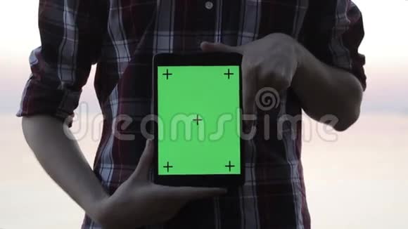 一个拿着绿色屏幕平板电脑的人视频的预览图
